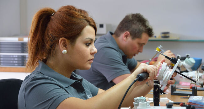 Frau und Mann, die Zahnprothesen herstellen