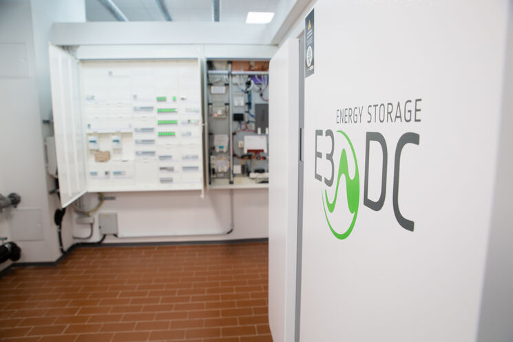 Im Vordergrund steht ein Speicher für Solaranlagen. Im Hintergrund sind die elektrischen Schaltkästen zu sehen.