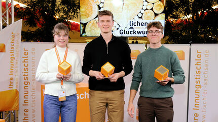 Drei junge Leute mit Auszeichnung in der Hand