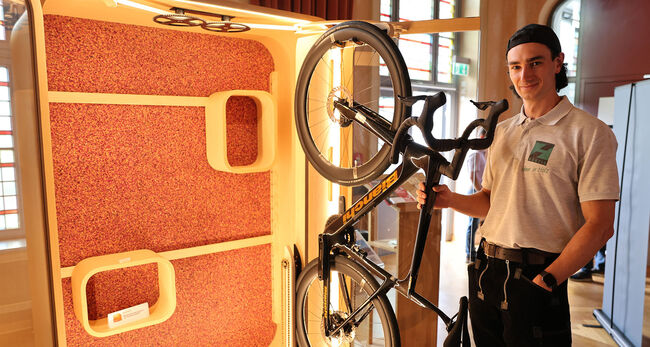 Mann mit Fahrrad vor Schrank in Ausstellung