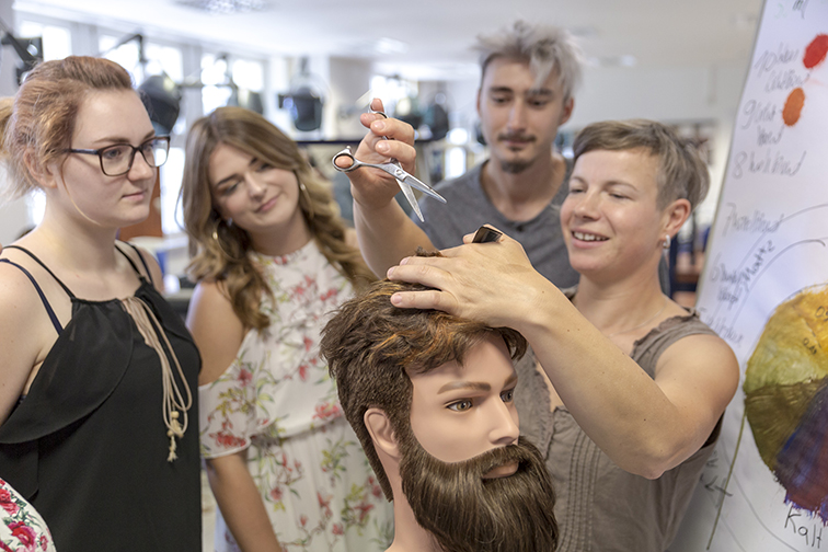 Das Bild zeigt eine Ausbildungssituation in der Friseurwerkstatt.